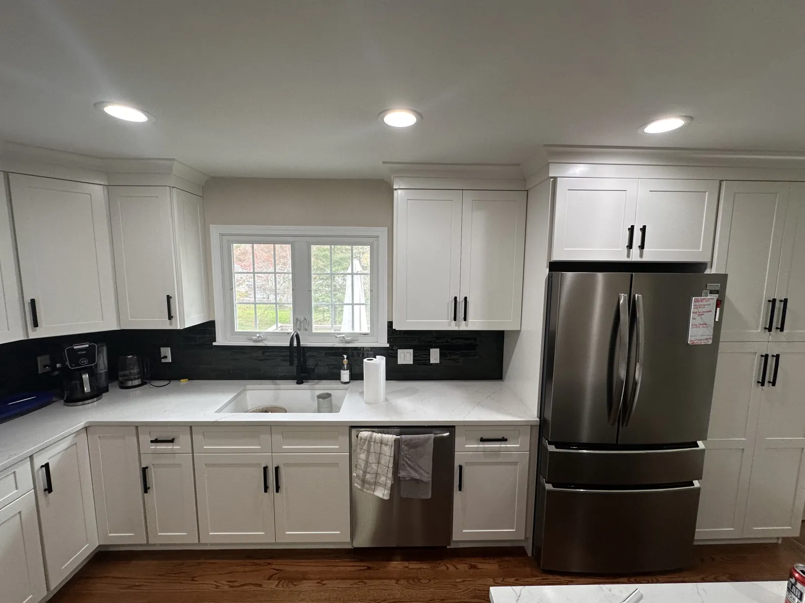 White shaker kitchen with dark backsplash