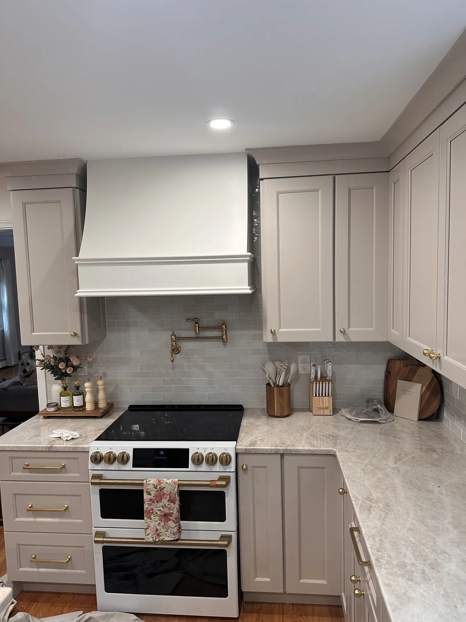 Greige kitchen with a custom white range hood